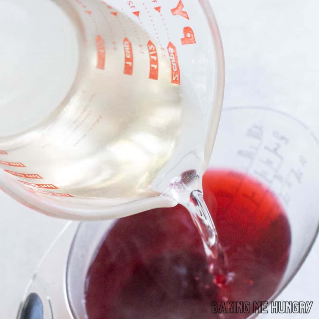 simple syrup being added to measuring cup