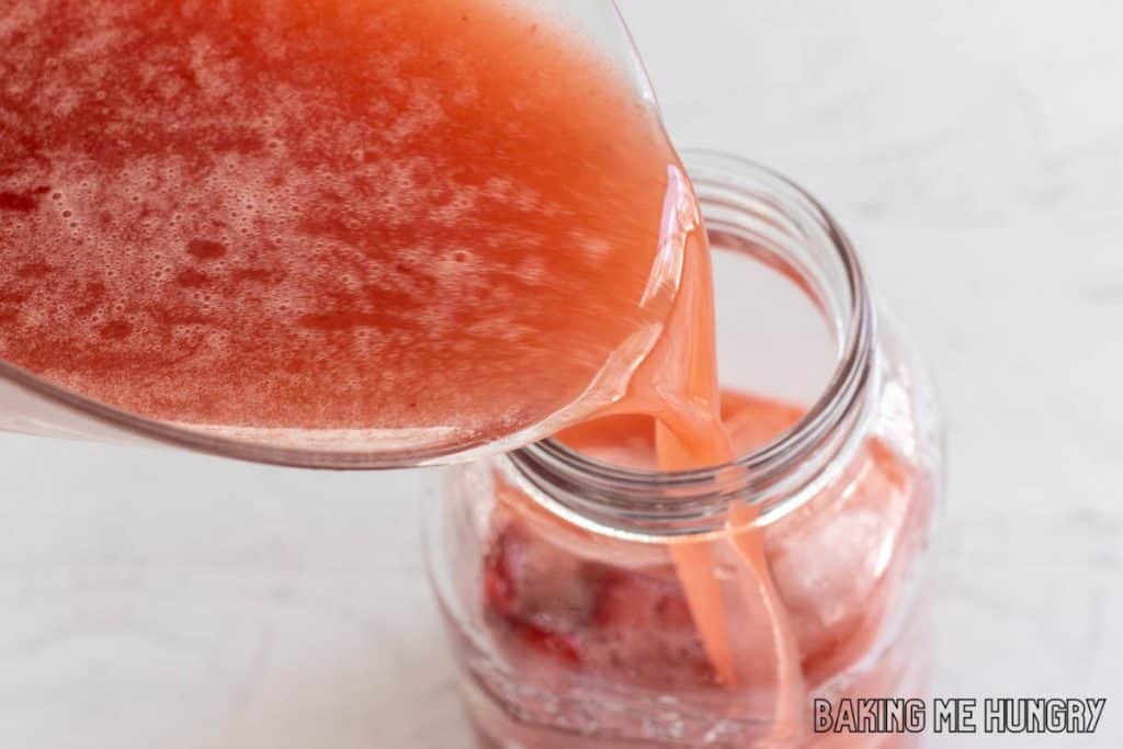 red liquid being poured into mason jar