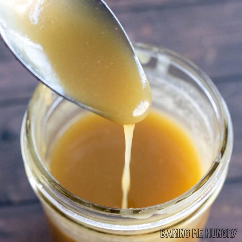 spoon with caramel sauce dripping into jar