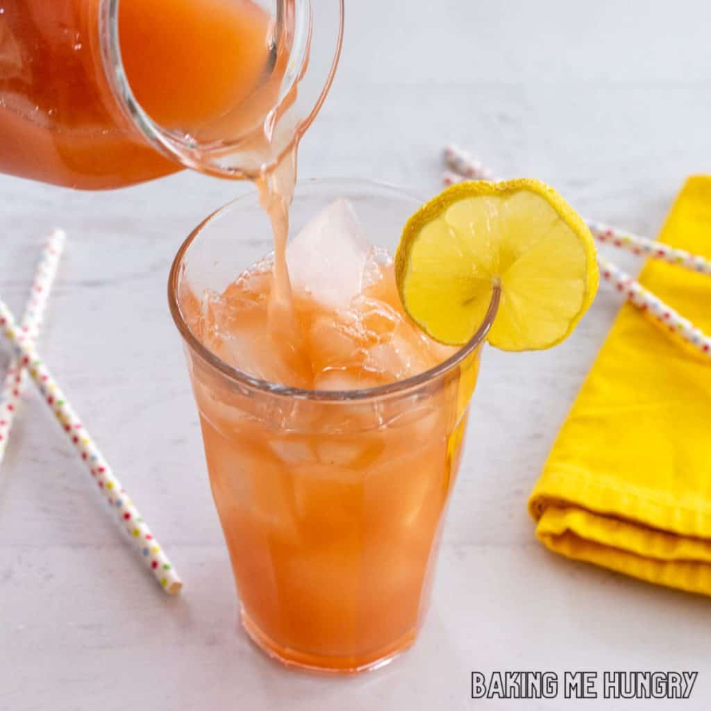 iced guava white tea lemonade recipe being poured into a glass of ice