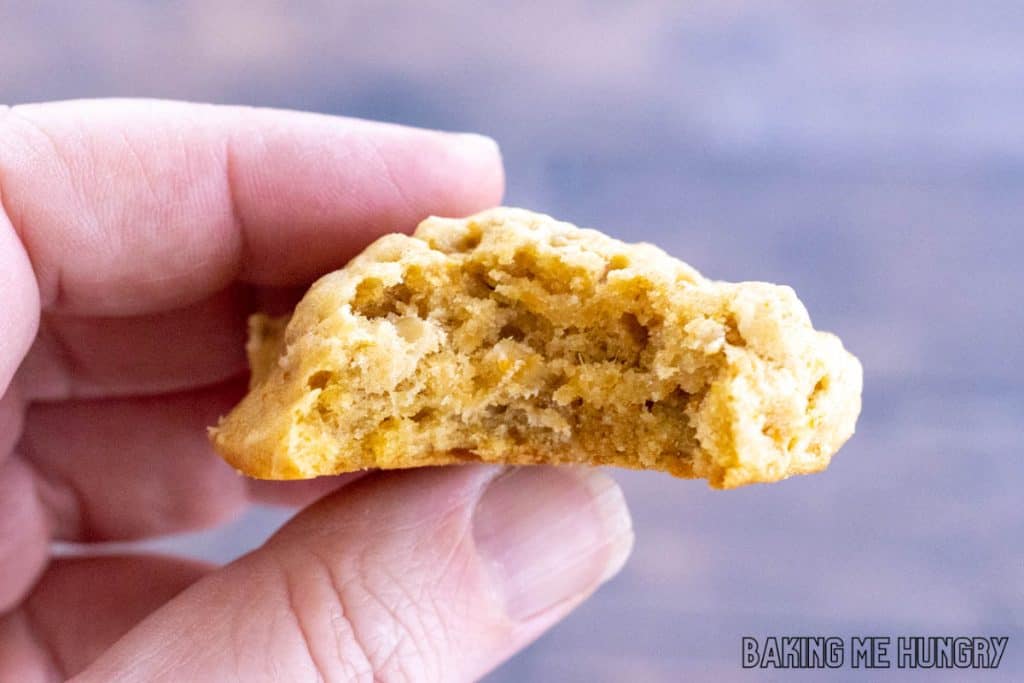 hand holding one of the sweet potato oatmeal cookies with a bite missing