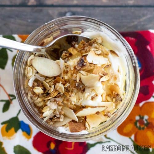 vanilla almond granola recipe in jar with yogurt and strawberries