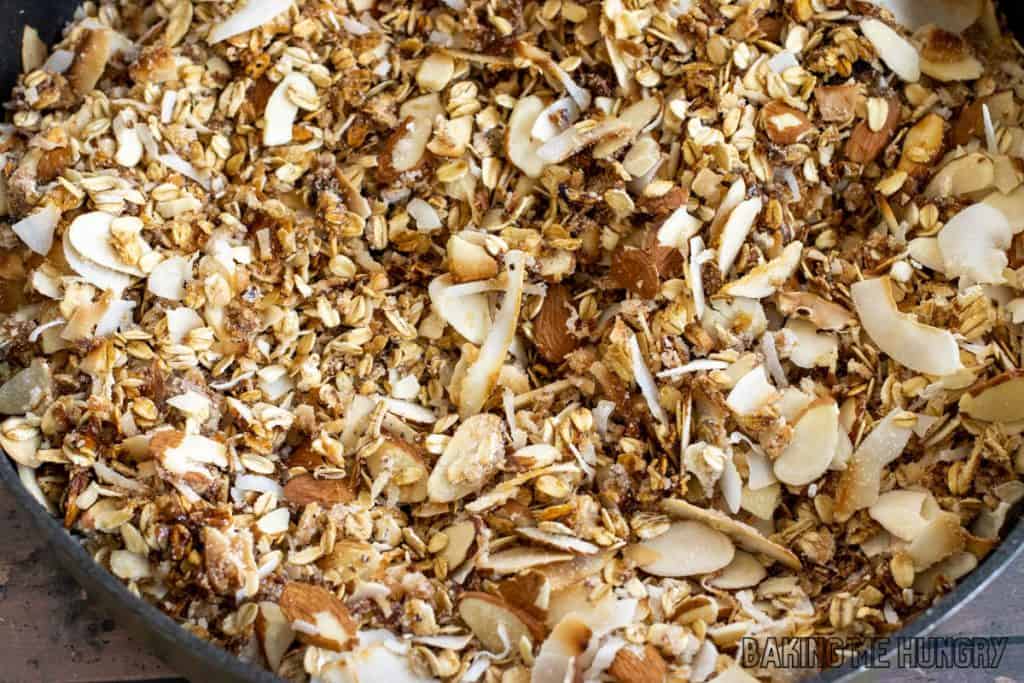 sugar coated toasted nuts, oats, and coconut in pan
