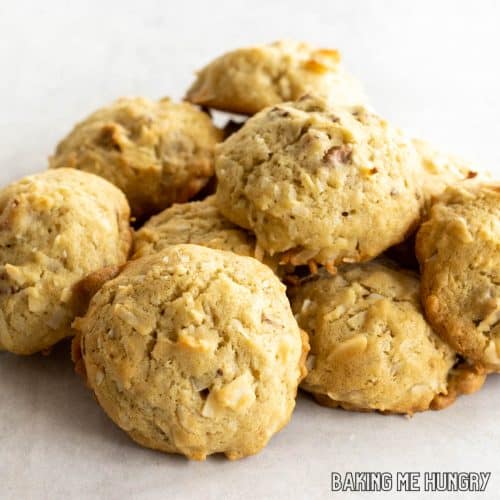 coconut pecan cookies in a pile on white surface