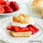 lemon biscuits recipe shown as strawberry shortcake cut and filled with strawberries and whipped cream on plate