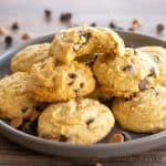 chocolate chip butterscotch cookies recipe piled on a serving plate with top cookie missing a bite