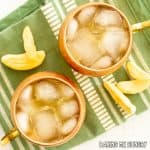mango mule mocktail in two copper mugs close up from overhead on green towel