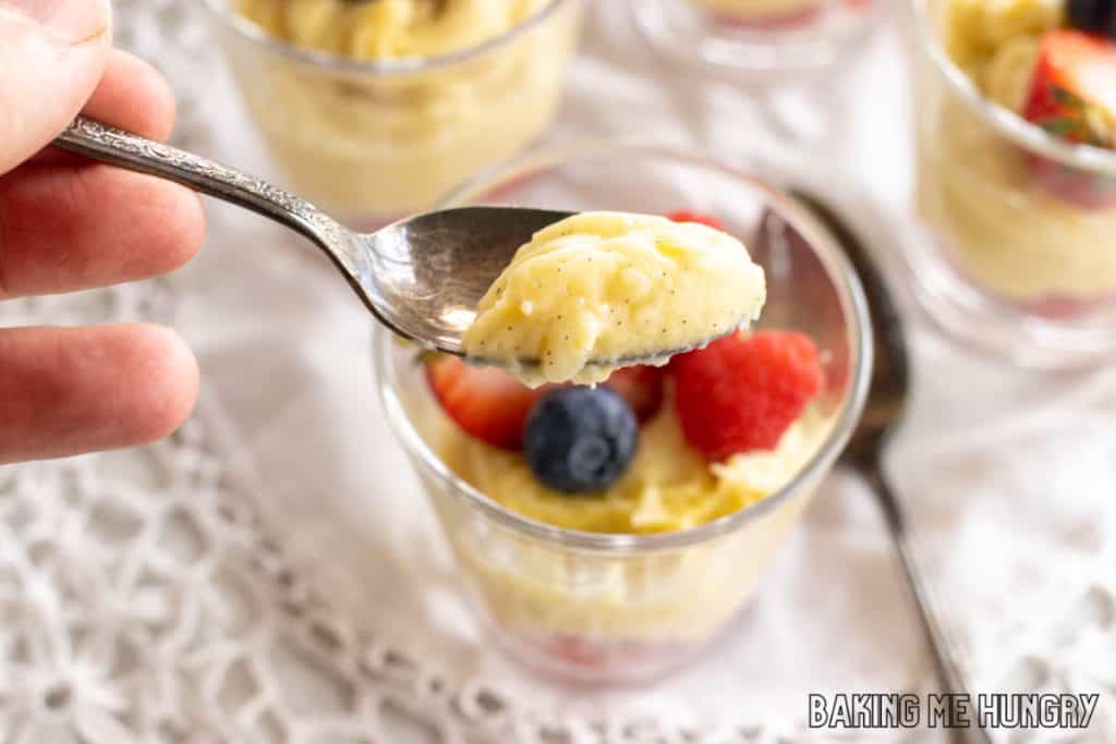 hand holding up spoon with bite of vanilla bean custard