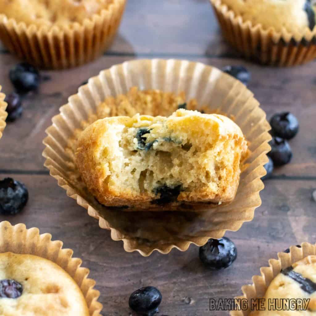 muffin with bite missing sitting on paper liner