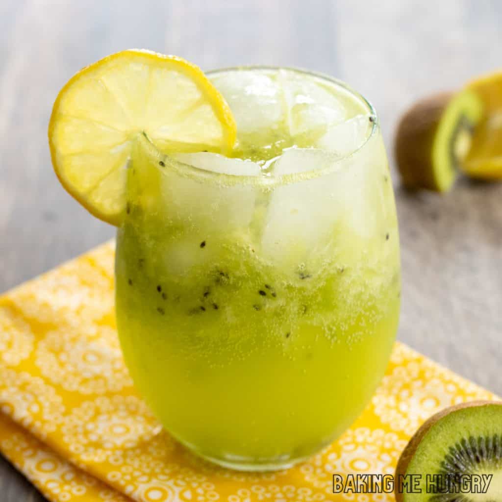 kiwi mocktail recipe in wine glass with lemon garnish close up