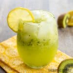 kiwi mocktail recipe in wine glass with lemon garnish close up