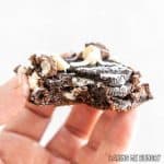 hand holding one of the cookies and cream cookie bars missing a bite
