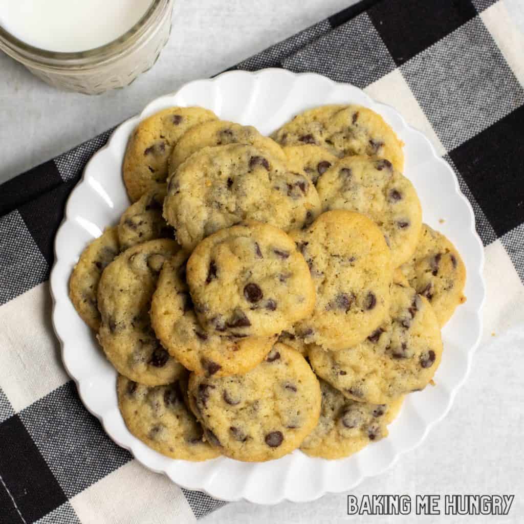 mini chocolate chip cookies on a plate next to a glass of milk