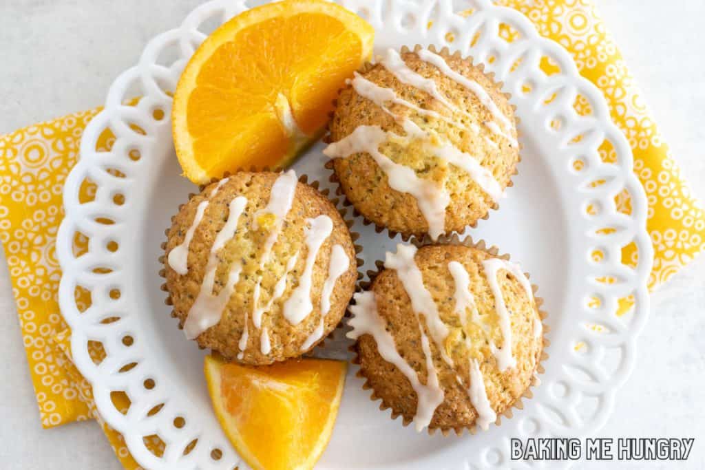 orange poppy seed muffins on a plate with orange slices
