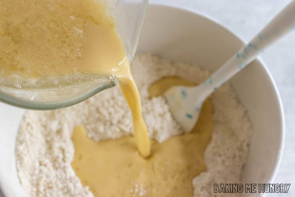 wet ingredients being poured into bowl of dry ingredients