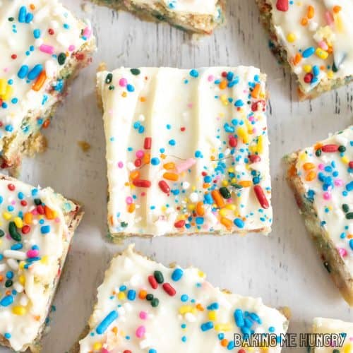 birthday cake blondies recipe spread out on white surface from overhead close up
