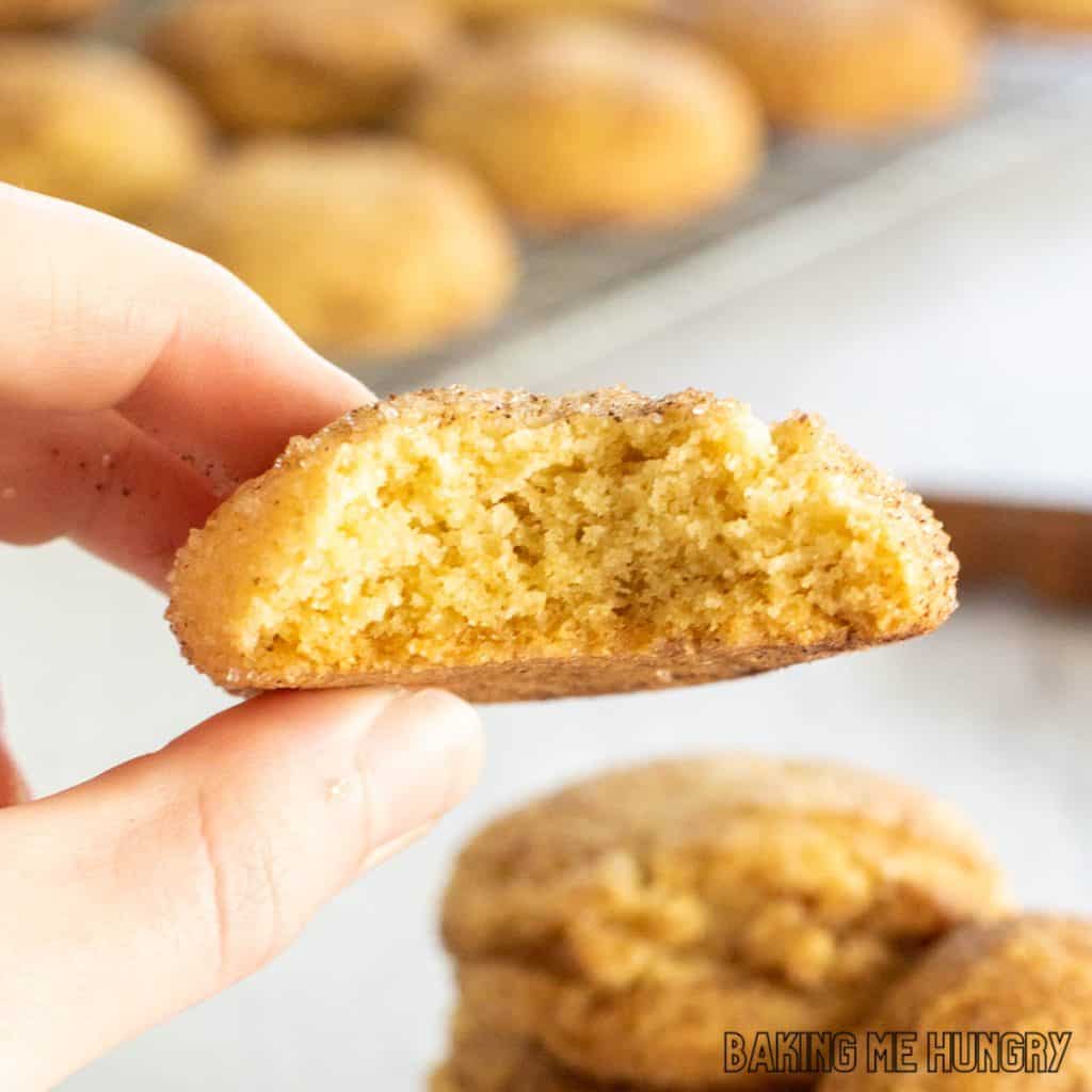 browned butter snickerdoodle cookie missing a bite being held up by a hand