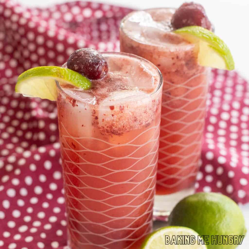 cherry mocktail recipe close up in two glasses with cherries and limes as garnish