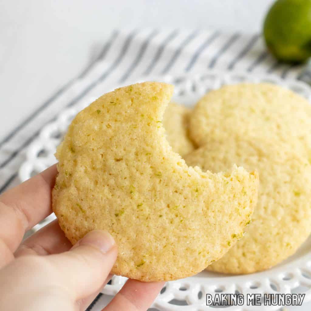 hand holding one of the lime sugar cookies missing a bite