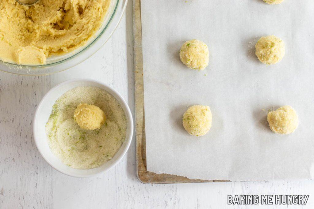 cookie dough being rolled in sugar and zest mixture