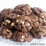 chocolate cookies and cream cookies piled on a glass serving plate