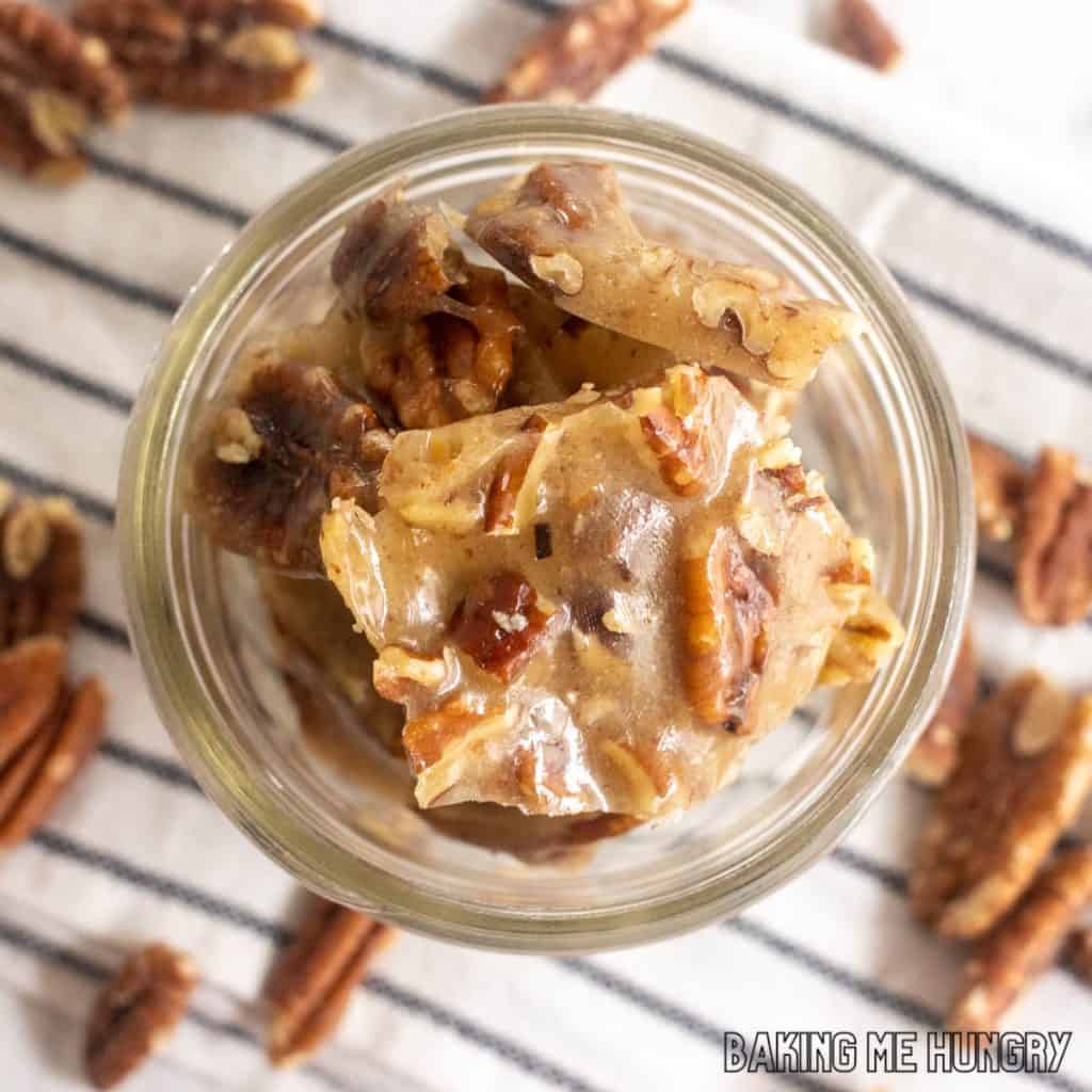 old fashioned pecan brittle in glass jar on striped napkin from overhead