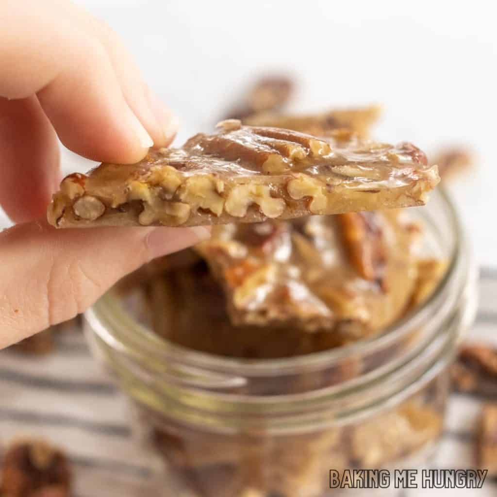 hand holding a piece of the pecan brittle