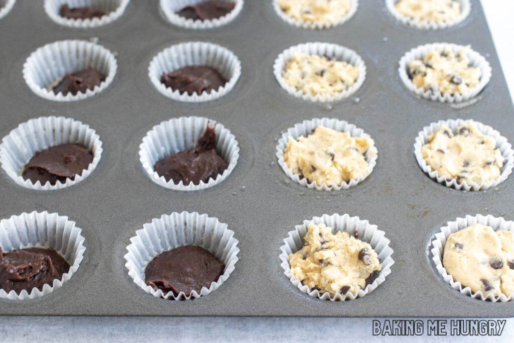 mini muffin tin with cookie dough on top of brownie batter