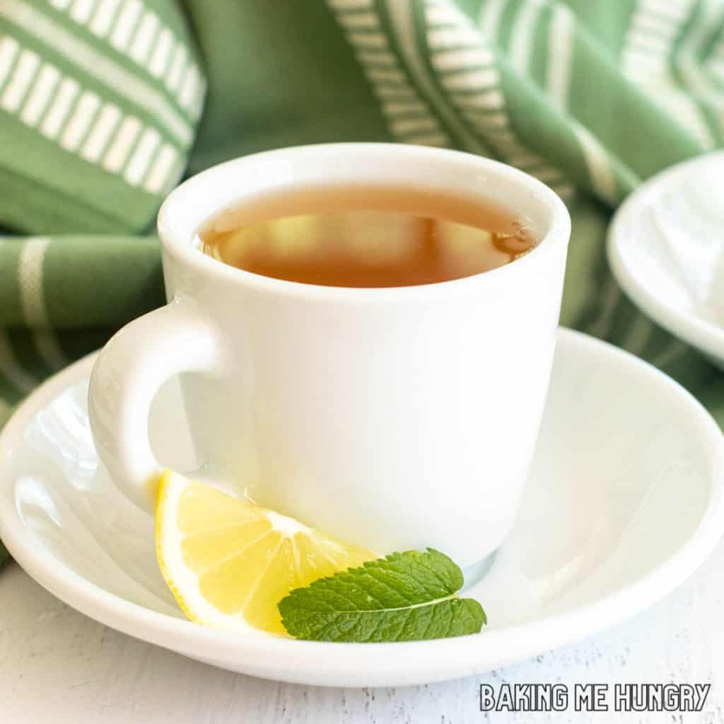 honey citrus mint tea recipe in white porcelain tea cup on saucer close up
