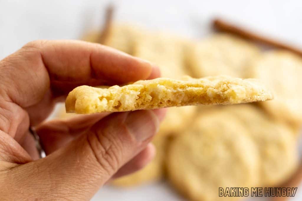 hand holding one of the cinnamon white chocolate cookies with a bite missing