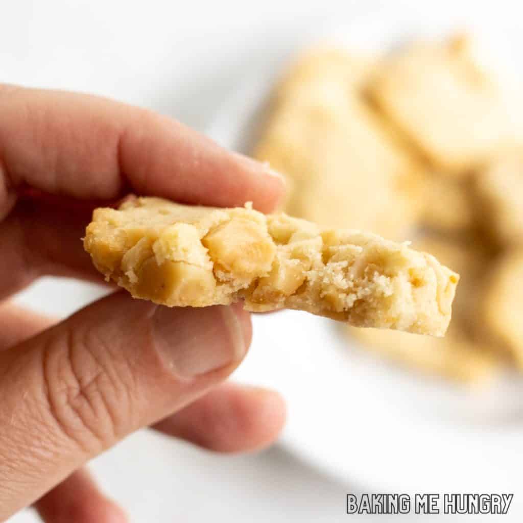 hand holding one of the macadamia shortbread cookies with a bite missing