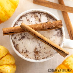 pumpkin chai latte recipe in a large mug with whipped cream and cinnamon sticks close up