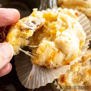 cheese and bacon muffins recipe shown as hand pulling muffin apart to show strings of cheese close up