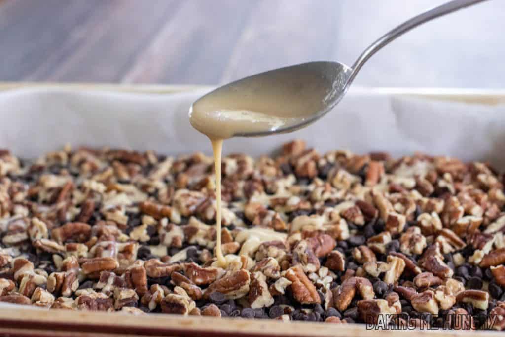 spoon drizzling liquid over toppings