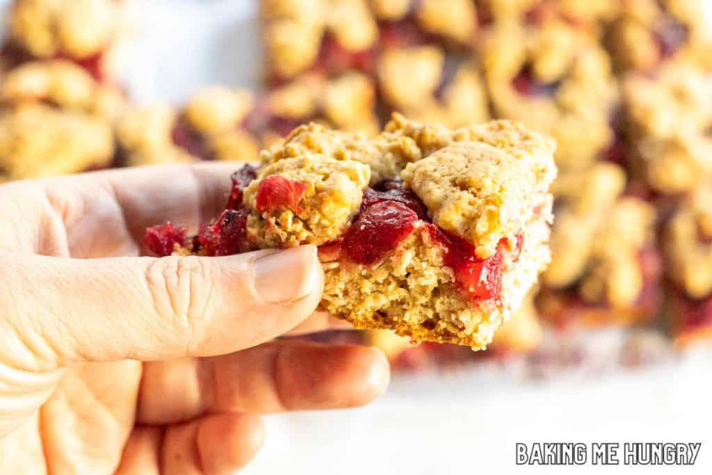hand holding one of the cranberry crumble bars