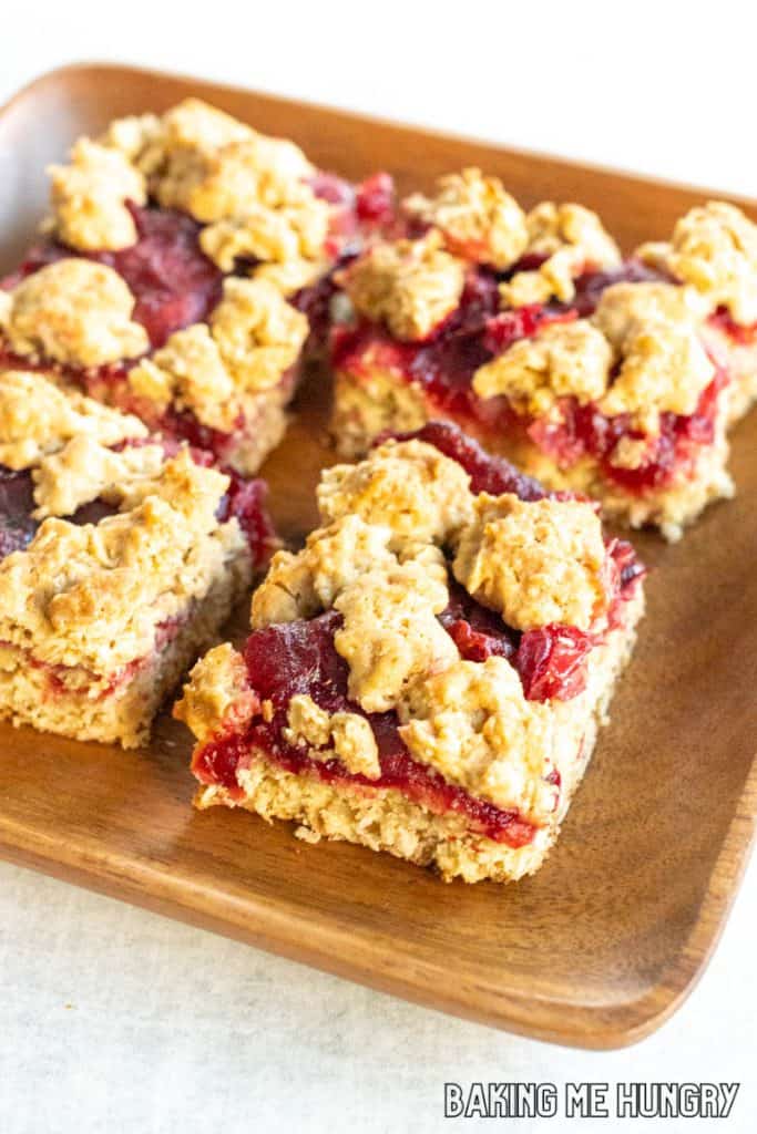 cranberry crumble bars recipe on wood serving plate