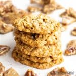 oat and pecan brittle cookies in a stack surrounded by pieces of pecan brittle