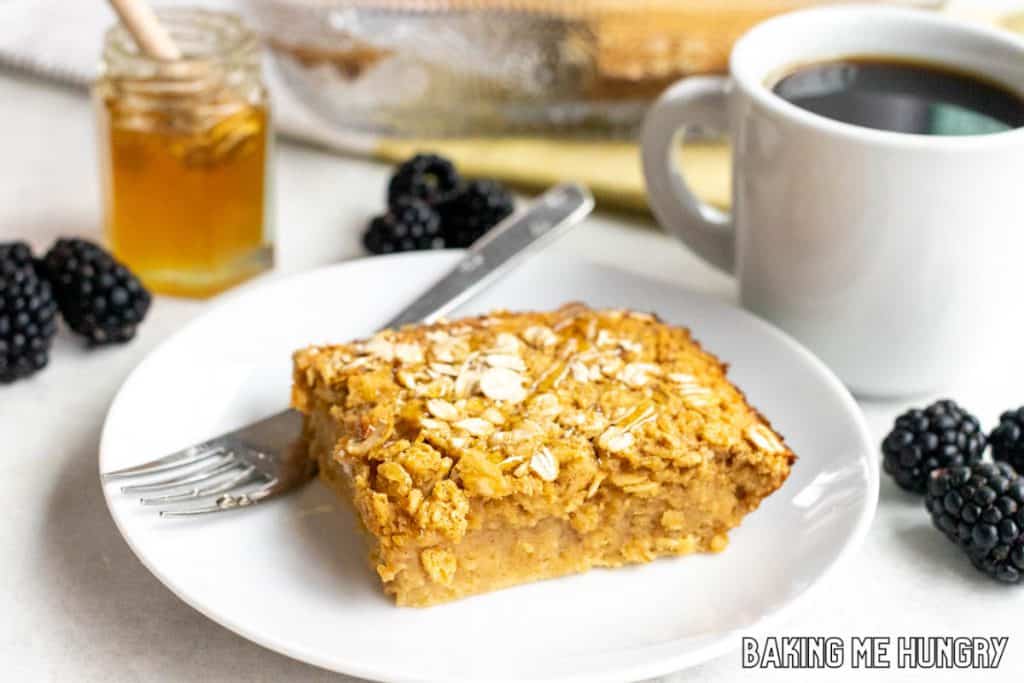 peanut butter baked oatmeal on a plate with coffee and berries behind