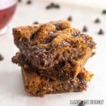 dark chocolate raspberry blondies recipe cut into squares and stacked with tea behind