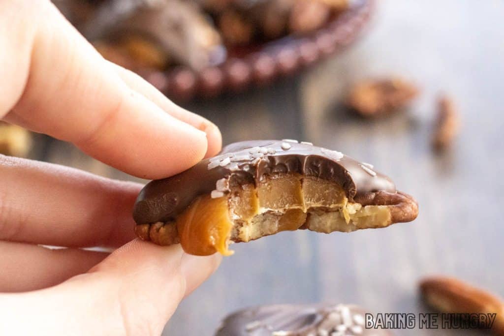 hand holding one of the pecan caramel candies missing a bite