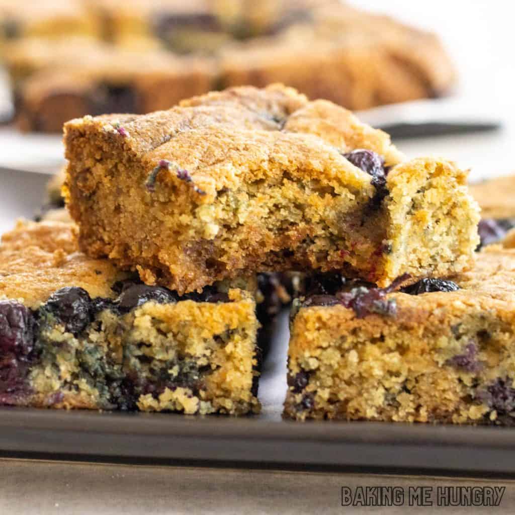 blueberry blondies recipe on serving tray with top bar missing a bite