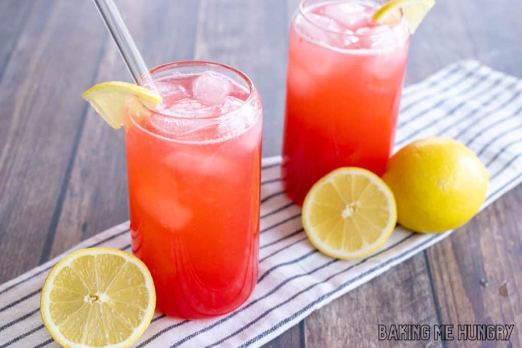 tall clear glasses with pink raspberry lemonade with lemon slices for garnish and glass straws