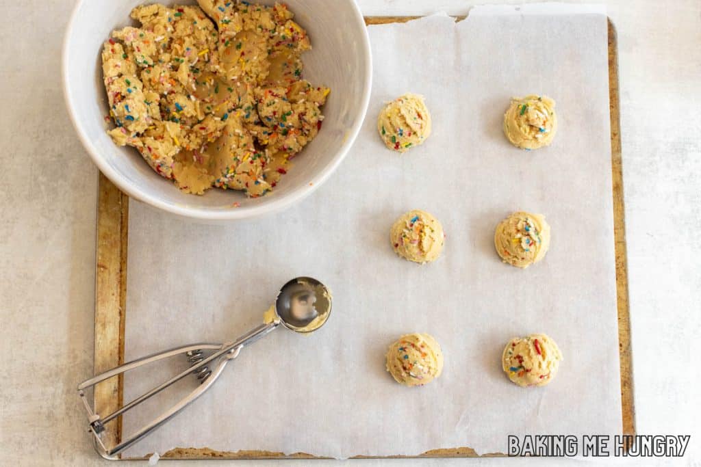 scoop next to dough balls and bowl of dough