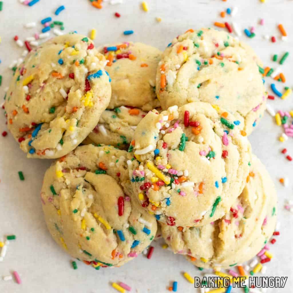 birthday sugar cookies in a pile surrounded by sprinkles