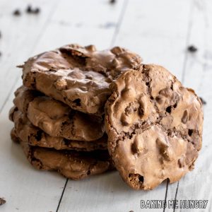 fudgy chocolate cookies in a stack with with one leaning