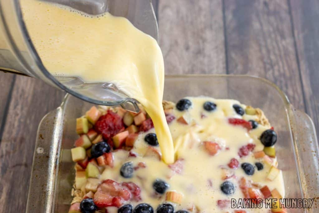 egg and milk mixture being poured from blended into baking dish