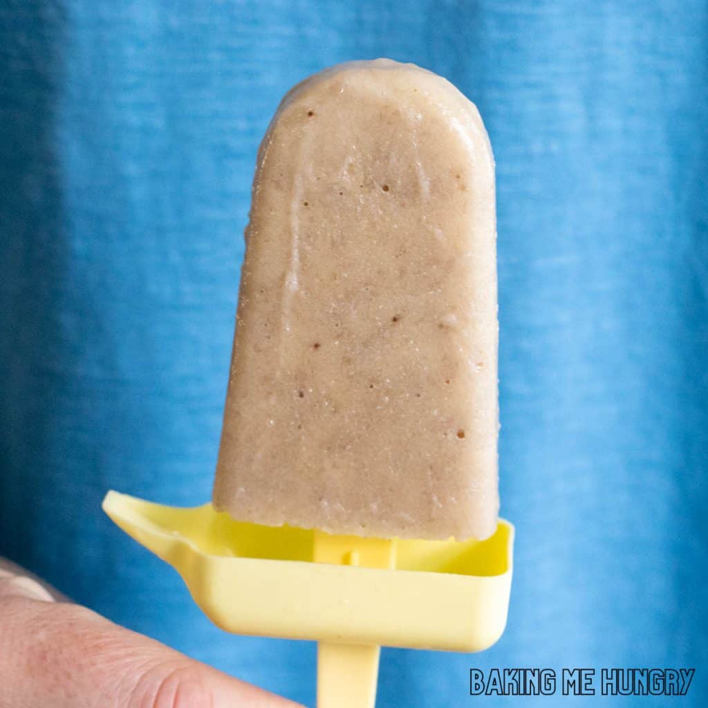 creamy banana popsicles recipe fresh banana pop held in front of blue background