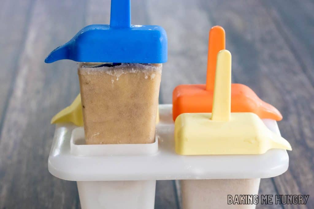 creamy banana popsicles recipe hand lifting an ice pop from mold