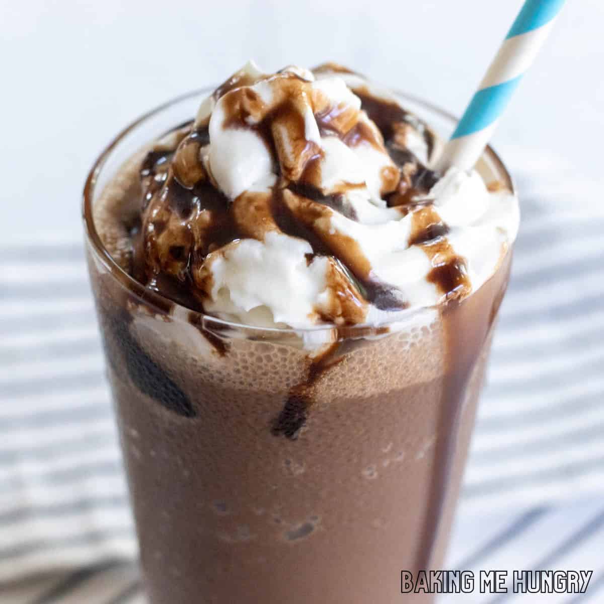 chocolate slushy recipe close up in a glass with whipped cream, chocolate syrup, and a straw from the side