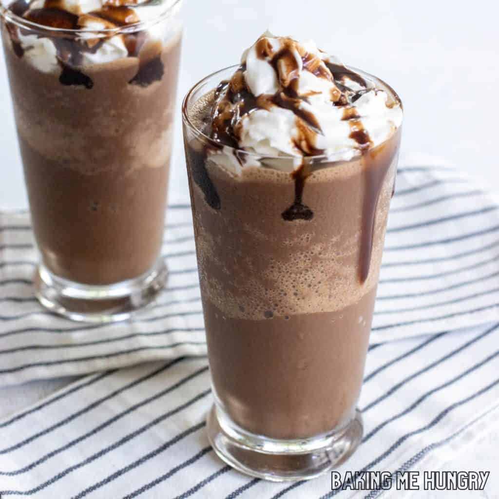 chocolate slushy recipe in two glasses with whipped cream and chocolate syrup